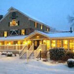 Outdoor patio seating surrounded by lush greenery at Water Wheel Tavern